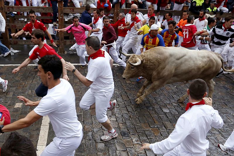 Los mozos corren delante del toro jabonero de la ganadería gaditana Fuente Ymbro en la curva de Telefónica