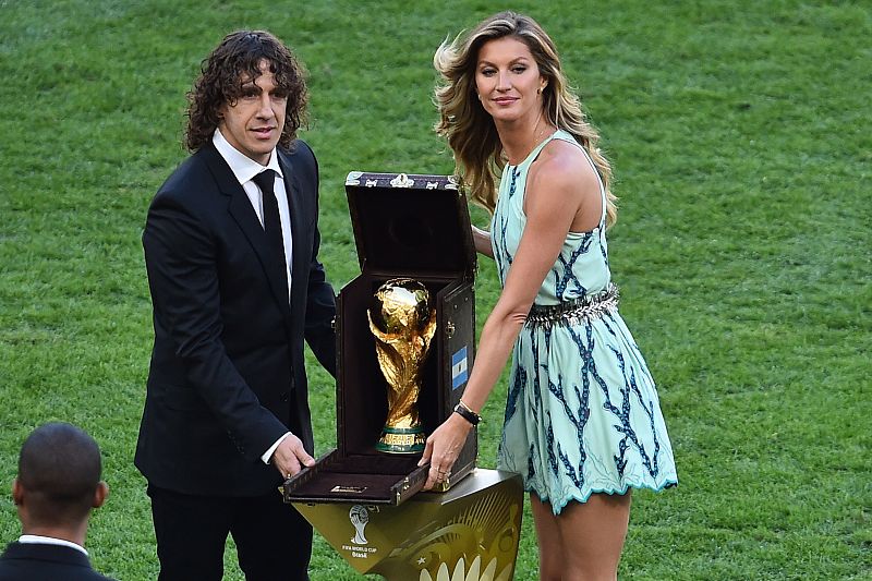 Carles Puyol y Gisele Bundchen entregan la copa.