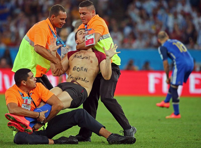 El personal de seguridad se lleva amordazado al espontáneo que saltó al césped.