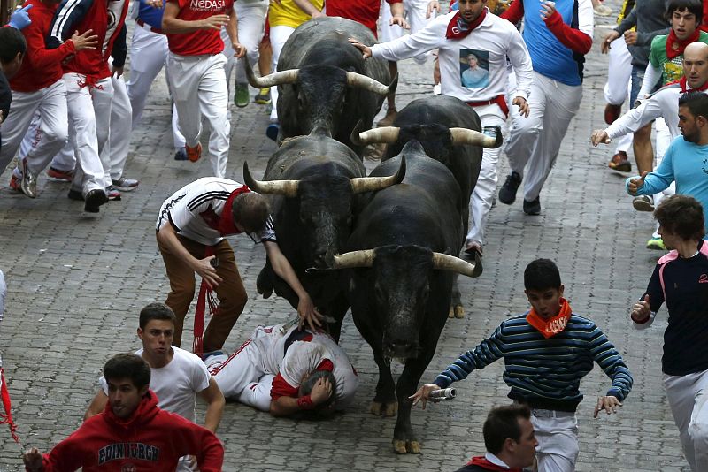 Varios mozos corren delante de los toros de Miura a la entrada al coso de Pamplona