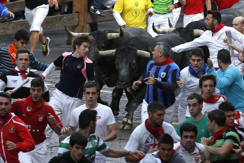 Varios mozos corren en el callejón de entrada al coso en el octavo y último encierro de los sanfermines 2014 