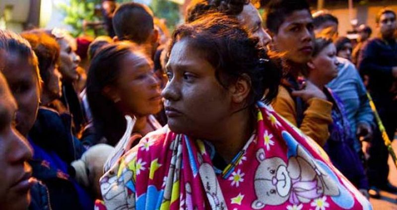 Una mujer con su hijo espera recibir información fuera del refugio "La Gran Familia"