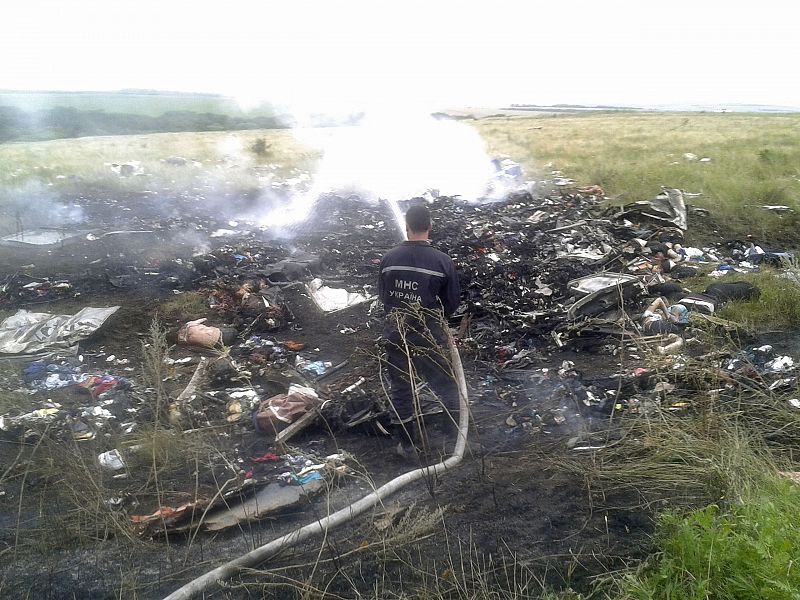 Man works at putting out a fire at the site of a Malaysia Airlines Boeing 777 plane crash in the settlement of Grabovo in the Donetsk region