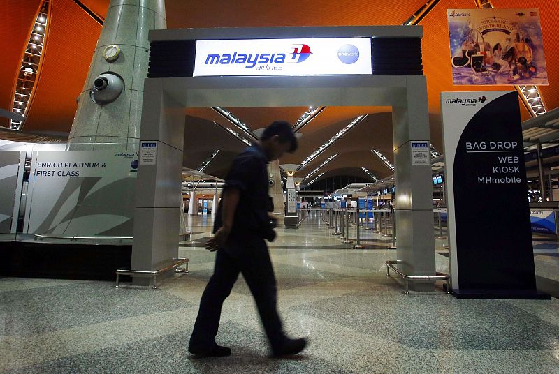 Man walks past the Malaysia Airlines check-in area at Kuala Lumpur International Airport in Sepang