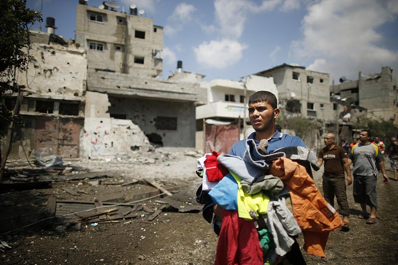 Un palestino recoge su ropa y huye del barrio de Shahiya, en el este de la Franja.