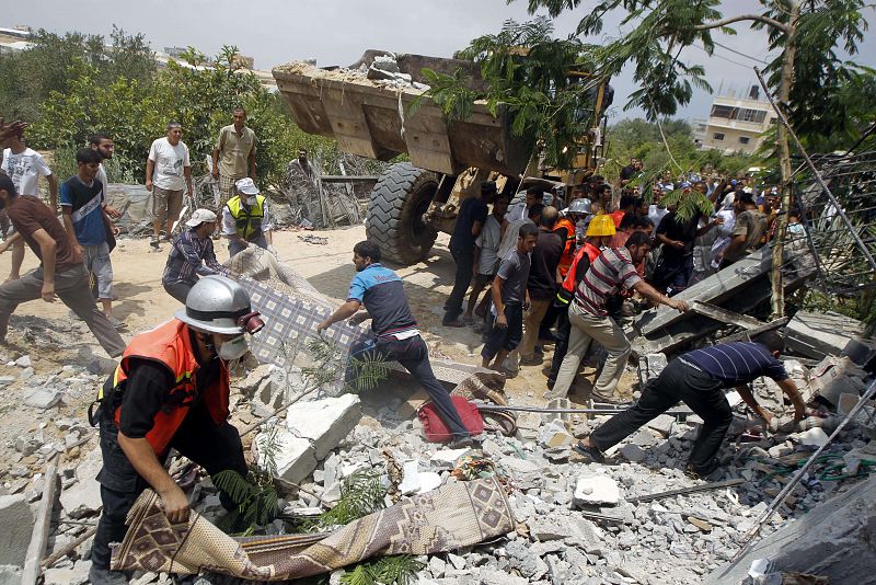 Los equipos de rescate buscan sobrevivientes bajo los escombros de una casa después de un ataque aéreo israelí en KhanYunis, en el sur de la franja de Gaza.