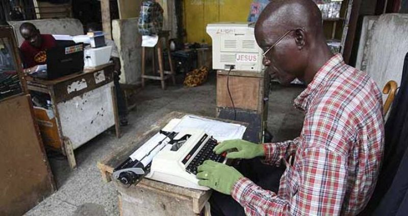 Un oficinista trabaja con guantes para evitar el contagio del virus en Monrovia.