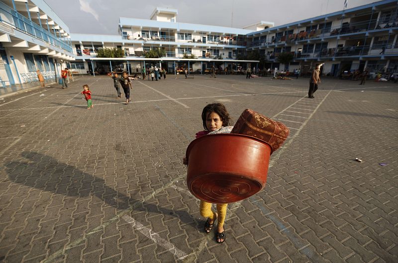 Una niña palestina abandona una escuela de las Naciones Unidas en Beit Lahia con sus pertenencias para volver a su casa durante la tregua de 72 horas.