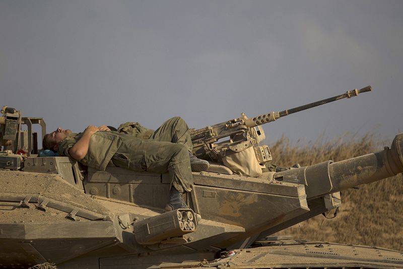 Un soldado descansa sobre un tanque Merkava en la frontera israelí tras su retirada de la Franja de Gaza