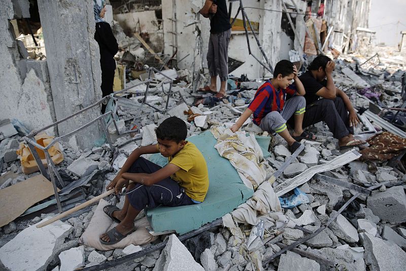 Niños palestinos sentados sobre las ruinas de sus casas a sue vuelta a Beit Hanoun, al norte de la Franja de Gaza