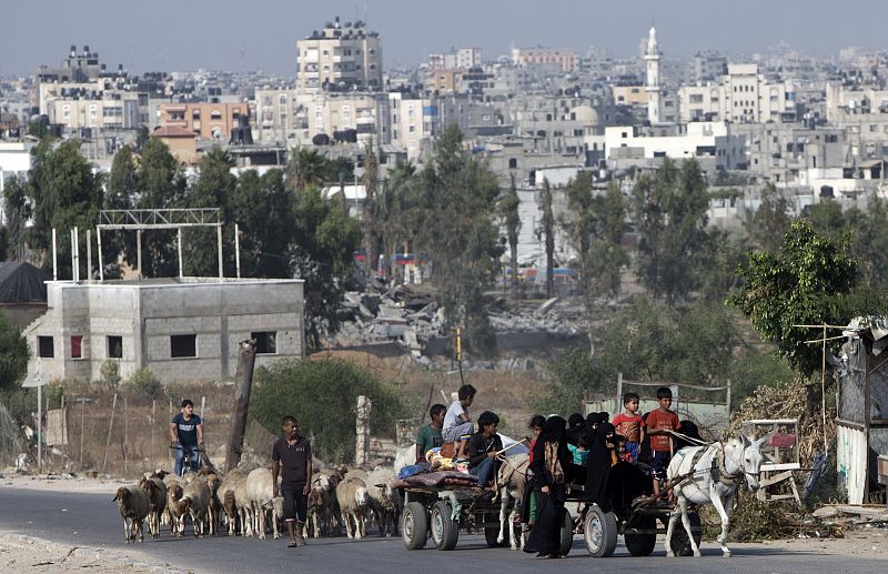 Mujeres y niños palestinos regresan en carro a sus casas en un pueblo beduino cerca de Beit Lahiya, al norte de la Franja de Gaza