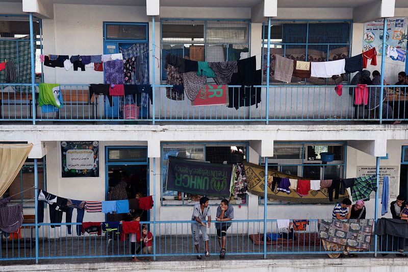 Un grupo de palestinos refugiados por los bombardeos de Israel habla en una escuela de la ONU en Gaza