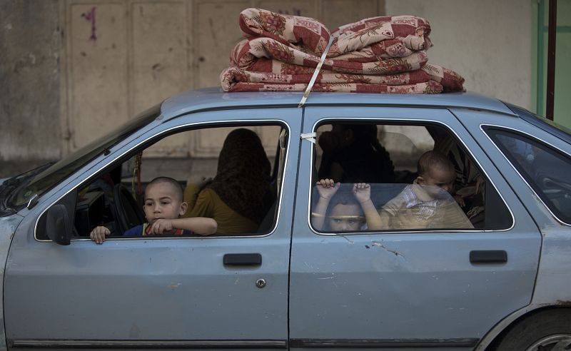 Una familia palestina abandona su casa en el barrio gazatí de Shejaiya una vez que se han reanudado los ataques sobre la ciudad