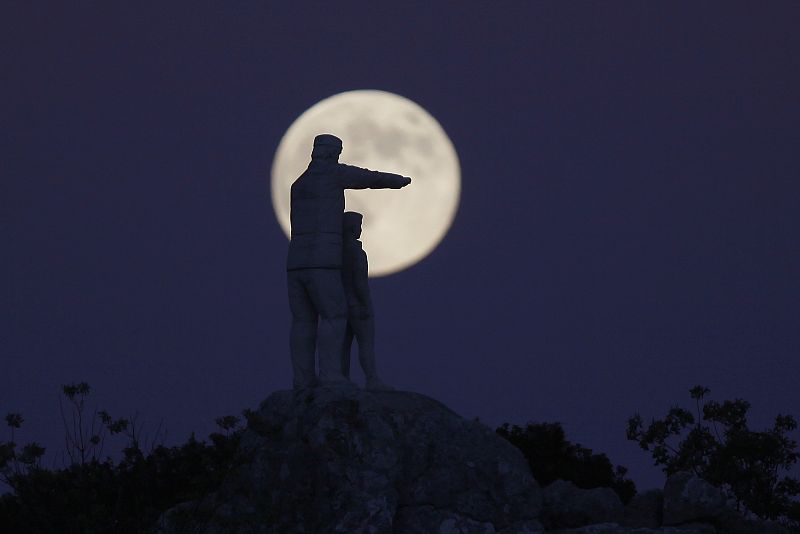Estatua del monumento dedicado a los guardabosques recortada por la superluna en la Sierra de las Nieves (Málaga).