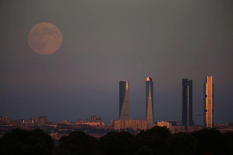 La superluna se levanta sobre las cuatro terres del Four Towers Business Area de Madrid.