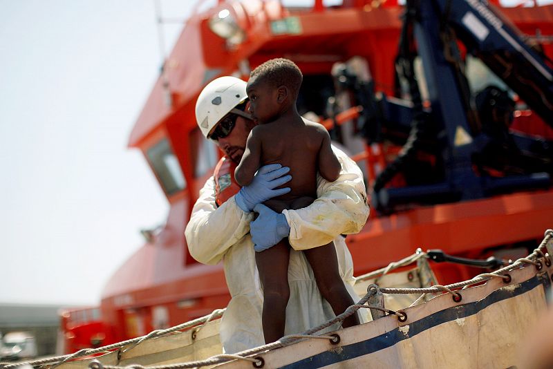 Un voluntario de Cruz Roja coge en brazos a uno de los niños rescatados en el Estrecho