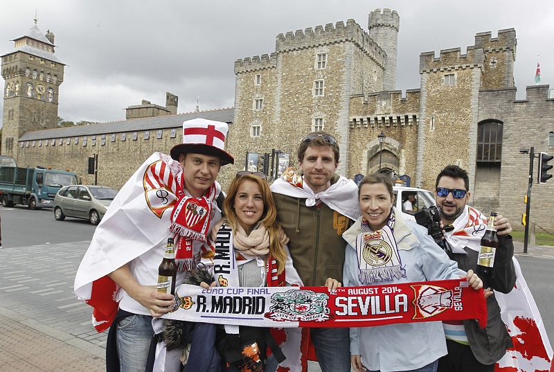 Aficionados del Sevilla y del Real Madrid posan en las calles de Cardiff (Gales), horas antes del comienzo del la final de la Supercopa de Europa.