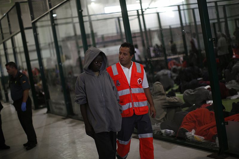 Una mujer es acompañada por un miembro de Cruz Roja en Tarifa