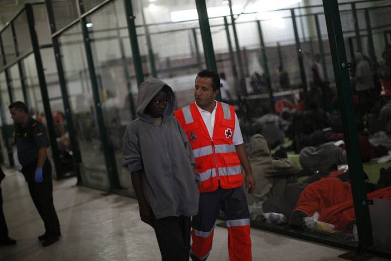 Una mujer es acompañada por un miembro de Cruz Roja en Tarifa