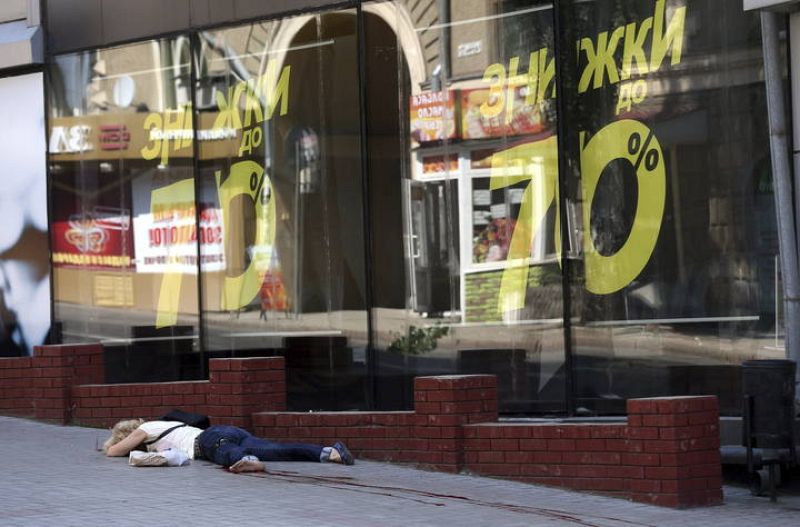 Una mujer permanece herida en el suelo tras el ataque en el centro de Donetsk, Ucrania