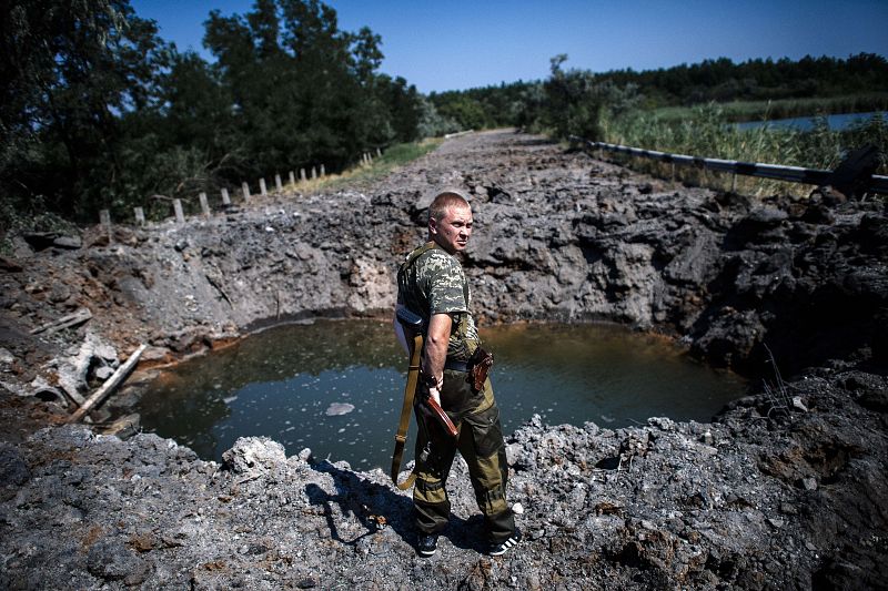 Un soldado prorruso al lado de un cráter de bomba cerca del centro de Donetsk