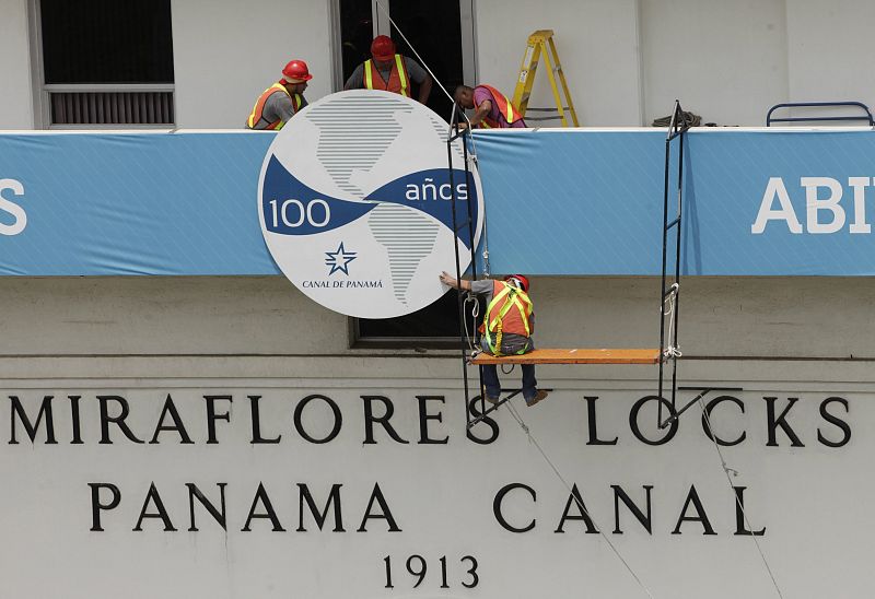 Trabajadores colocan el cartel para celebrar los cien años del Canal