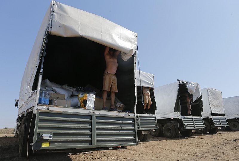 Drivers of a Russian convoy of trucks carrying humanitarian aid for Ukraine show the contents of their trucks at a camp near Kamensk-Shakhtinsky