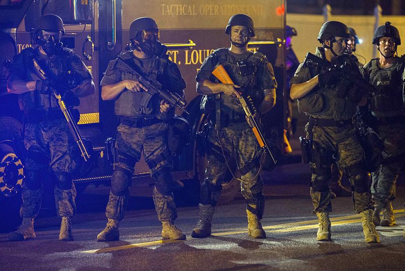 Police officers react to the movements of a rowdy group of demonstrators during protests in reaction to the shooting of Michael Brown near Ferguson, Missouri