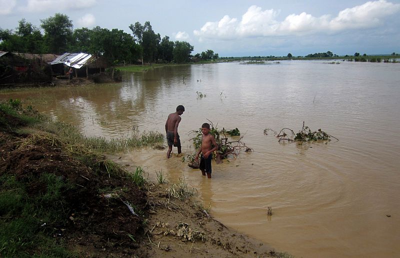 Nepalíes caminan por zonas inundadas en el distrito de Banke, a 351 km al oeste de Katmandú