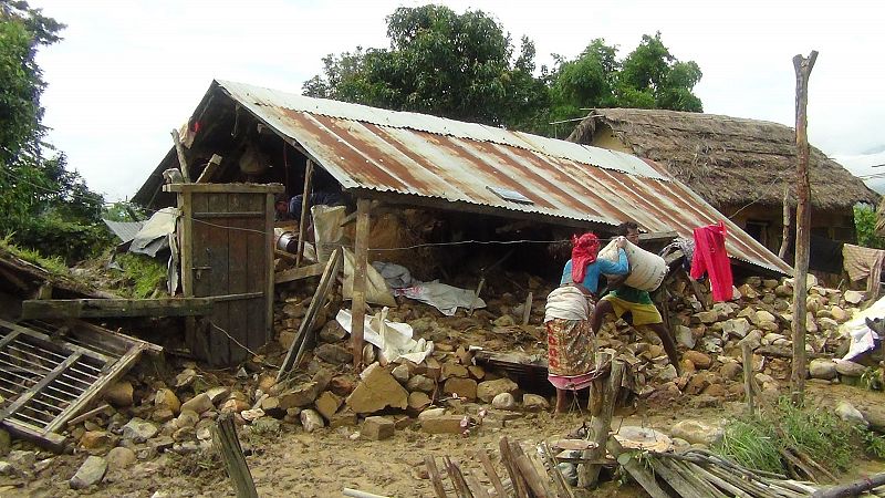 Nepalíes recogen comida de sus casas dañadas por las inundaciones en distrito de Surkeht, a 400 km de Katmandú