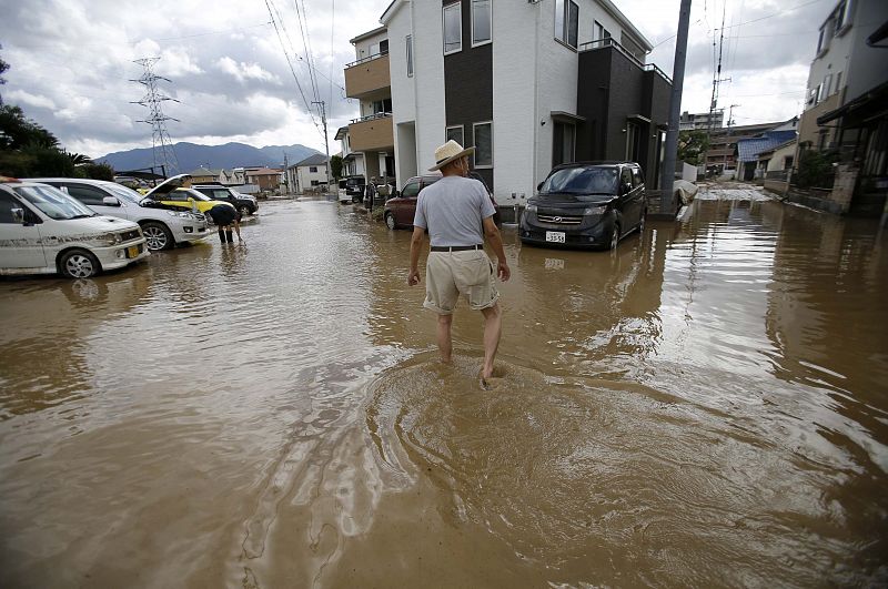 Un habitante de la localidad japonesa de Hiroshima camina por las calles inundadas