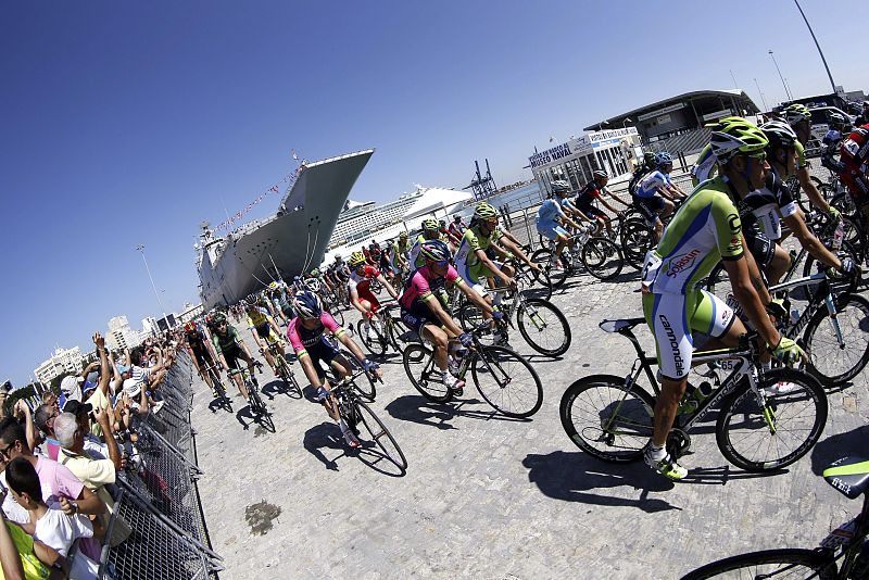 Momento de la salida de la tercera etapa de la Vuelta Ciclista a España 2014 en el que el pelotón abandonaba el mayor barco de guerra de la Armada Española.