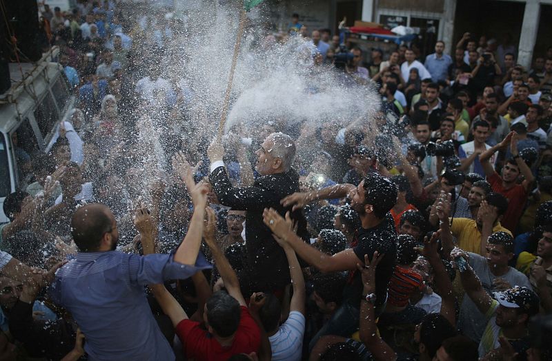 Hamas spokesman Fawzi Barhoum is carried by Palestinians as they celebrate what they said was a victory over Israel, following a ceasefire in Gaza City