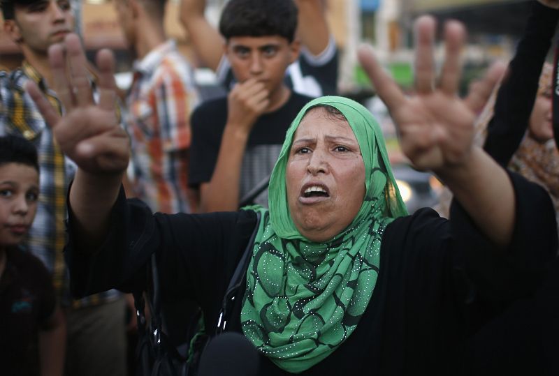 A Palestinian woman celebrates with others what they said was a victory over Israel, following a ceasefire in Gaza City