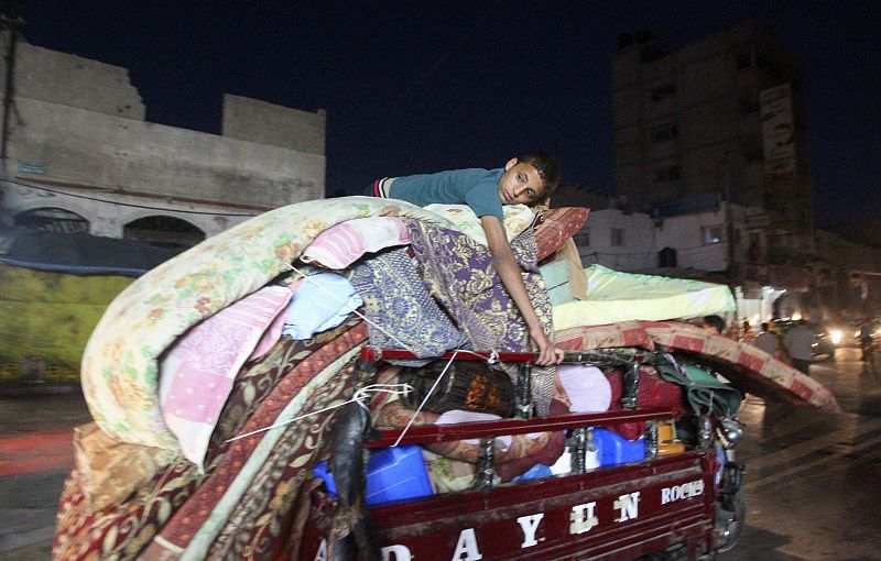 Palestinian boy rides in a motorbike rickshaw as he returns to his family's house in Shejaia neighborhood, which witnesses said was heavily hit by Israeli shelling and air strikes during Israeli offensive, following a ceasefire in Gaza City