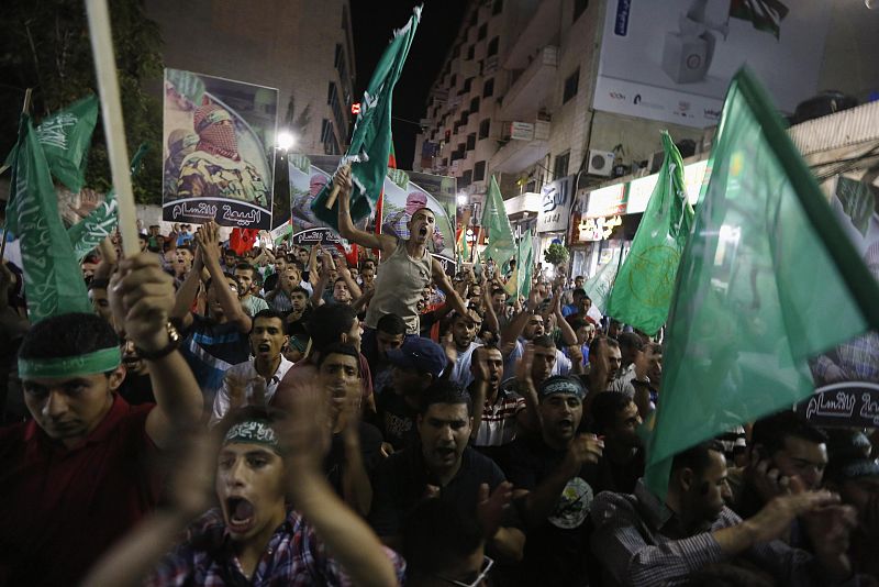 Palestinians celebrate what they said was a victory by Palestinians in Gaza over Israel following a ceasefire, in the West Bank city of Ramallah