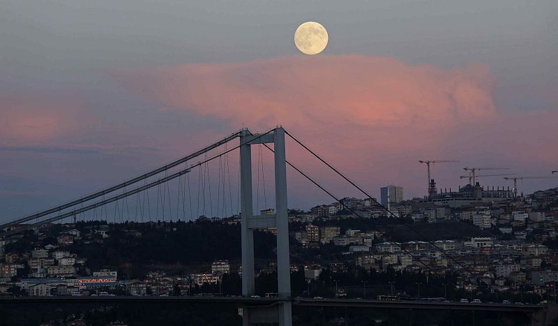La luna cuelga del cielo sobre el puente colgante de Estambul sobre el Bósforo.