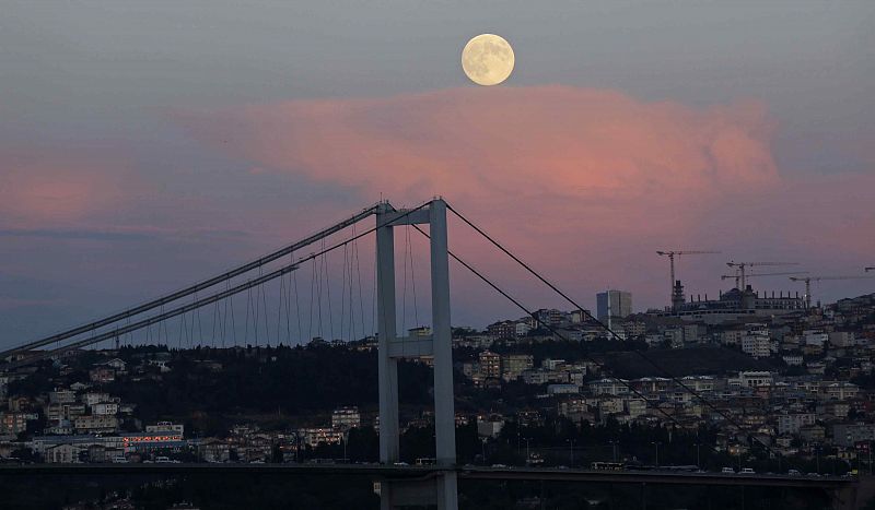 La luna cuelga del cielo sobre el puente colgante de Estambul sobre el Bósforo.