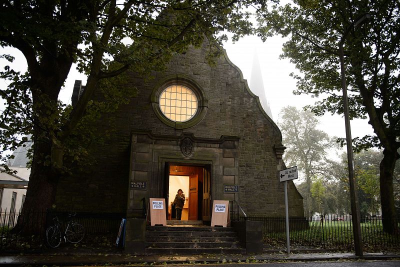 Una madrugadora votante sale de un colegio electoral en Edimburgo