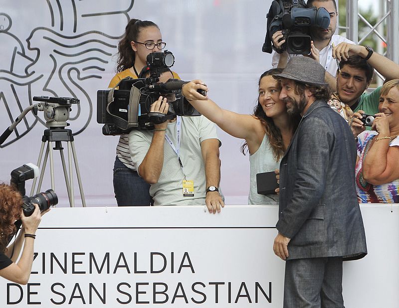 El actor Antonio de la Torre se fotografía con una admiradora, a su llegada hoy a San Sebastián para participar en la 62 edición del Festival de Cine donostiarra