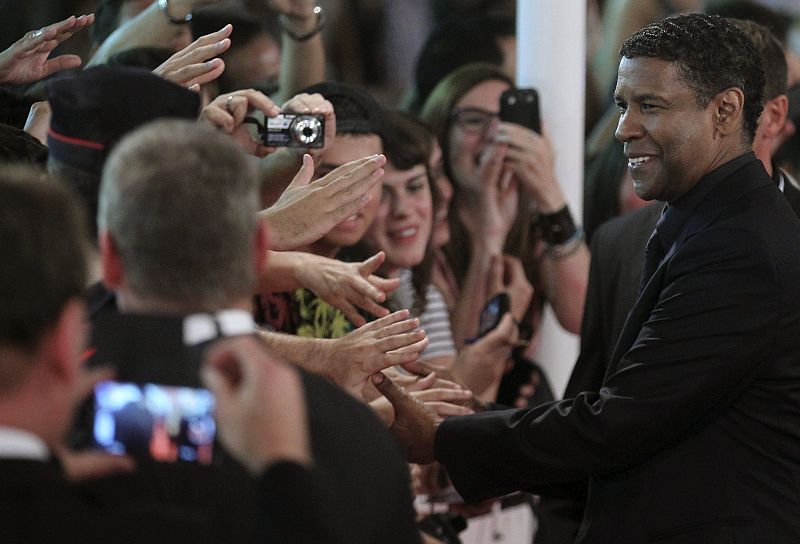 El actor estadounidense Denzel Washington saluda a sus seguidores en la alfombra roja de San Sebastián antes de presentar "El Protector", su última película