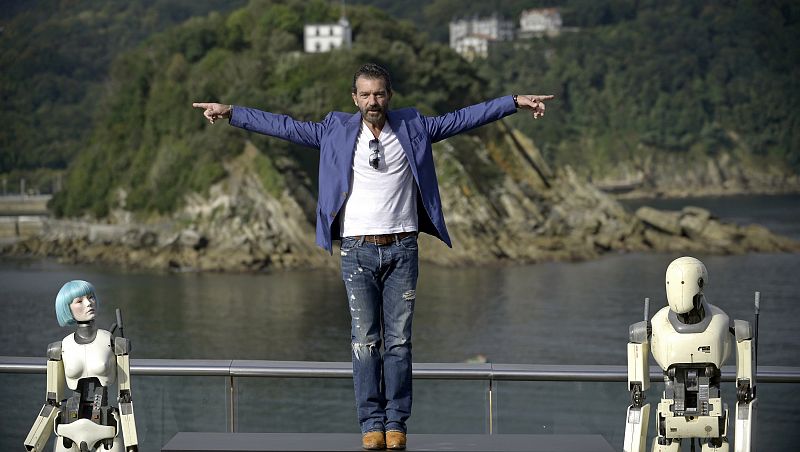 Spanish actor Banderas poses alongside robots used in the film Automata during a photocall at the San Sebastian Film Festival