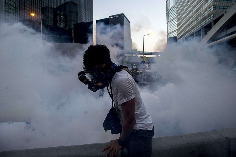 Un fotógrafo toma imágenes después que la policía lanzara gases lacrimógenos a los manifestantes cerca de la sede del gobierno de Hong Kong.