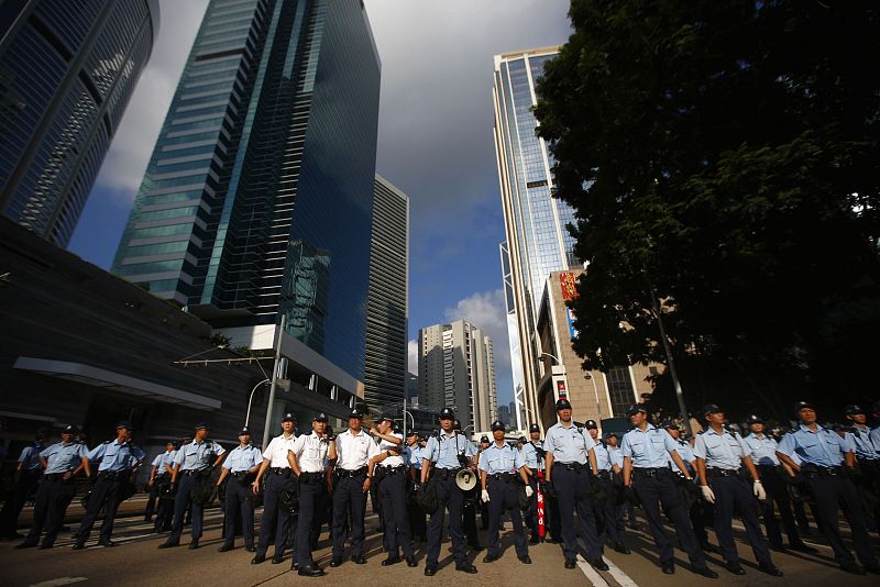 La policía forma un cordón para evitar que los manifestantes corten el tráfico del distrito financiero de Hong Kong.