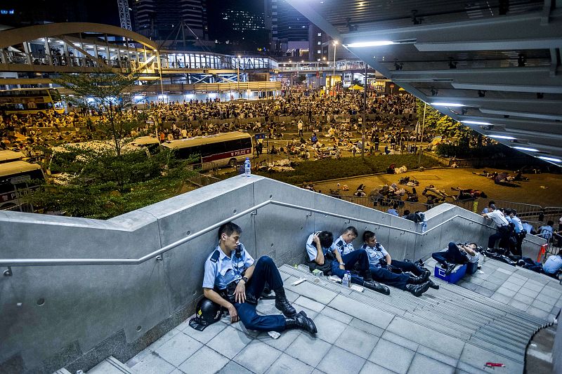 Los policías aprovechan un receso en las protestas para descansar después de una intensa jornada en las calles del distrito central de Hong Kong.