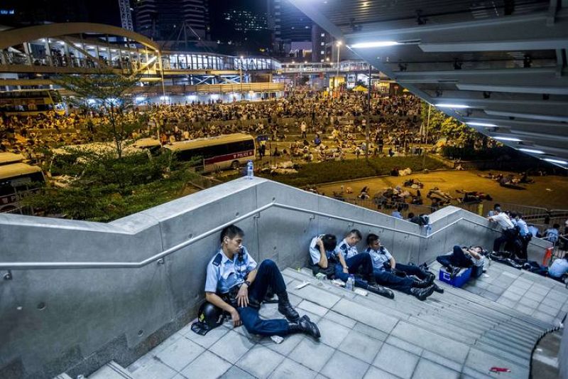 Los policías aprovechan un receso en las protestas para descansar después de una intensa jornada en las calles del distrito central de Hong Kong.