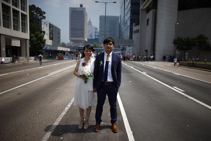 Vivian Lo y Ka Sing Fung, recien casados, posan en una calle desierta del distrito centro de Hong Kong.