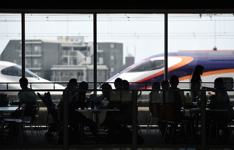 Visitantes del museo del ferrocarril observan un tren bala desde el restaurante