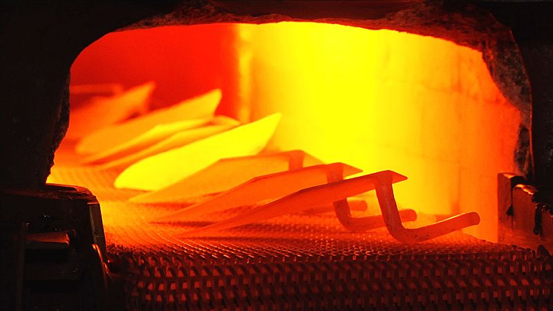 Los trozos de madera pasan por la fase de torneado y posteriormente se introducen en un bombo con barniz.