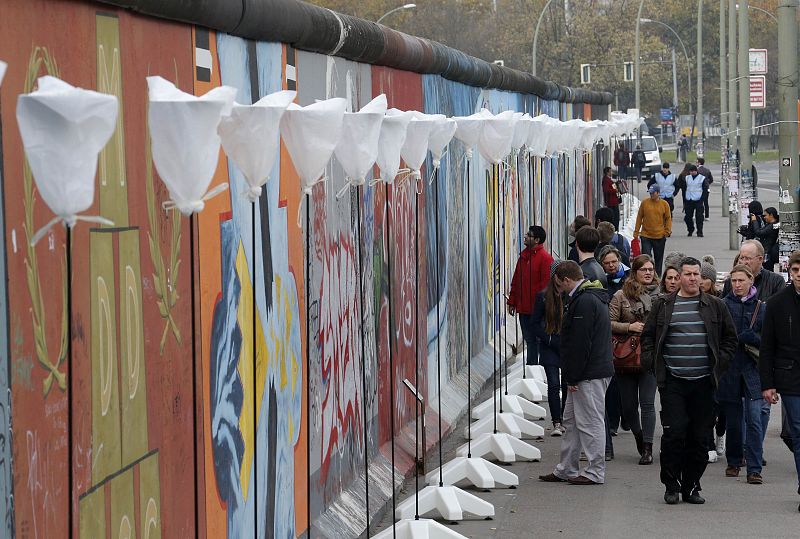 Varios turistas pasean entre los 8.000 globos que iluminarán la ciudad con motivo del 25 aniversario de la caída del Muro de Berlín.